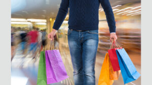 Man holds colored shopping bags to illustrate "shopping agreement"